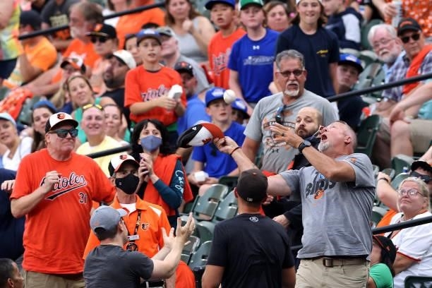 Fan attempts to catch a foul ball during the Baltimore Orioles and Toronto Blue Jays game at Oriole Park at Camden Yards on June 18, 2021 in...