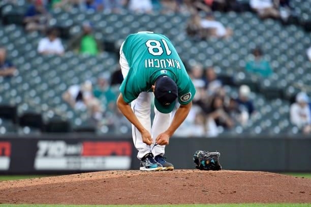 Yusei Kikuchi of the Seattle Mariners ties his shoes during the game against the Tampa Bay Rays at T-Mobile Park on June 18, 2021 in Seattle,...