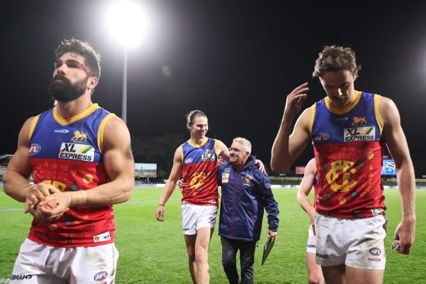 Eric Hipwood of the Lions and Lions head coach Chris Fagan celebrate victory with team mates after the round 14 AFL match between the North Melbourne...