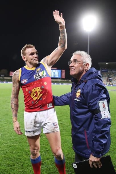 Mitch Robinson of the Lions and Lions head coach Chris Fagan celebrate victory after the round 14 AFL match between the North Melbourne Kangaroos and...