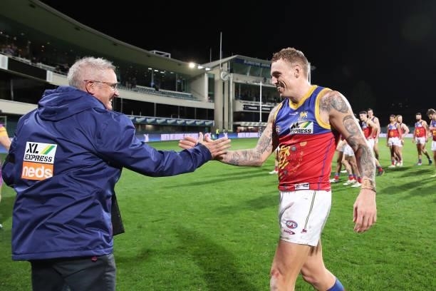 Mitch Robinson of the Lions and Lions head coach Chris Fagan celebrate victory after the round 14 AFL match between the North Melbourne Kangaroos and...