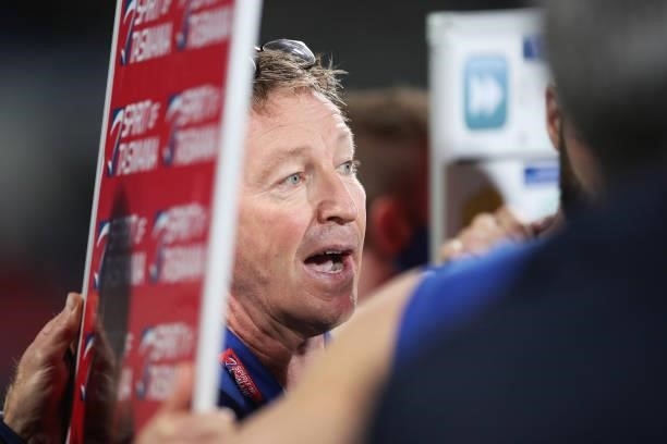 Kangaroos head coach David Noble speaks to players at three quarter time during the round 14 AFL match between the North Melbourne Kangaroos and the...