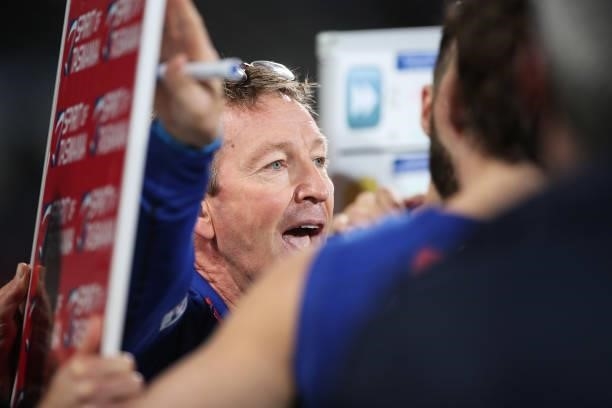 Kangaroos head coach David Noble speaks to players at three quarter time during the round 14 AFL match between the North Melbourne Kangaroos and the...