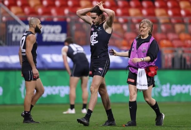 Matthew Cottrell of the Blues is attended to by a trainer during the round 14 AFL match between the Greater Western Sydney Giants and the Carlton...