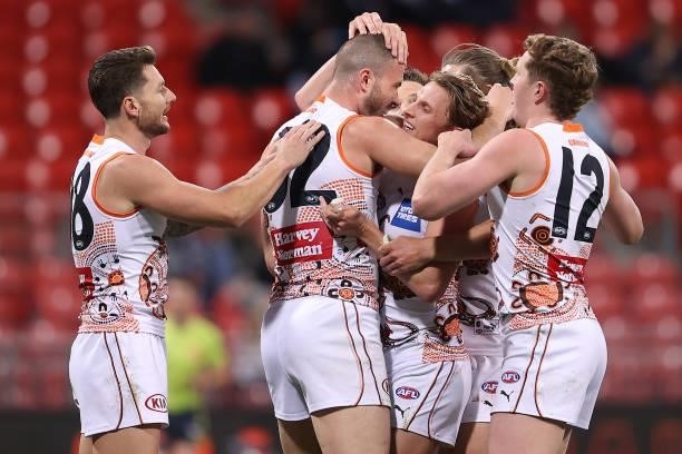 Kieren Briggs of the Giants is congratulated by team mates after kicking a goal during the round 14 AFL match between the Greater Western Sydney...