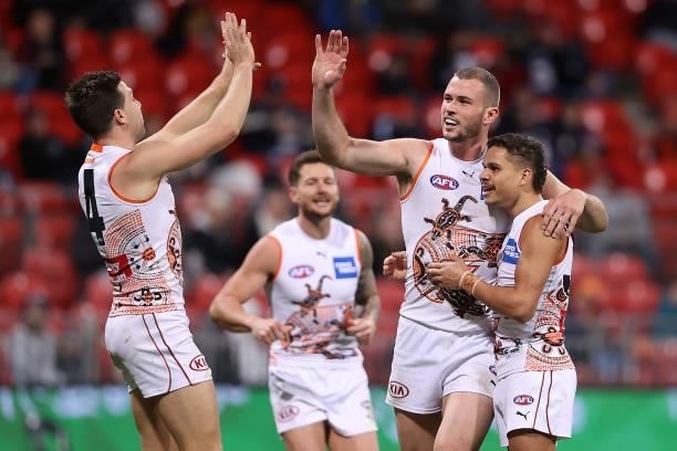 Kieren Briggs of the Giants is congratulated by team mates after kicking a goal during the round 14 AFL match between the Greater Western Sydney...