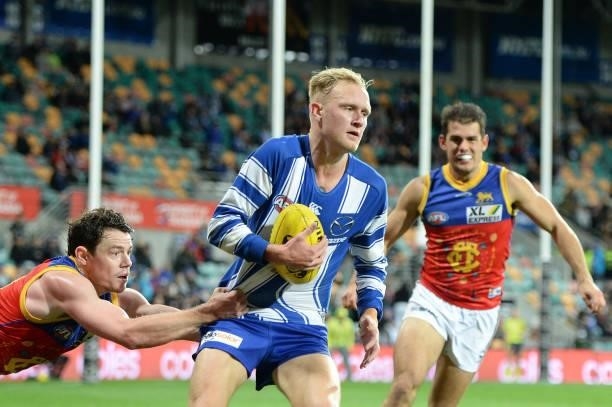 Jaidyn Stephenson of the Kangaroos is tackled by Lachie Neale of the Lions during the round 14 AFL match between the North Melbourne Kangaroos and...