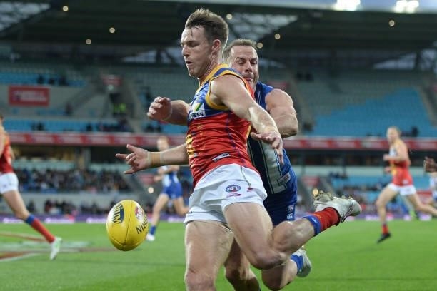 Lincoln McCarthy of the Lions is tackled by Josh Walker of the Kangaroos during the round 14 AFL match between the North Melbourne Kangaroos and the...
