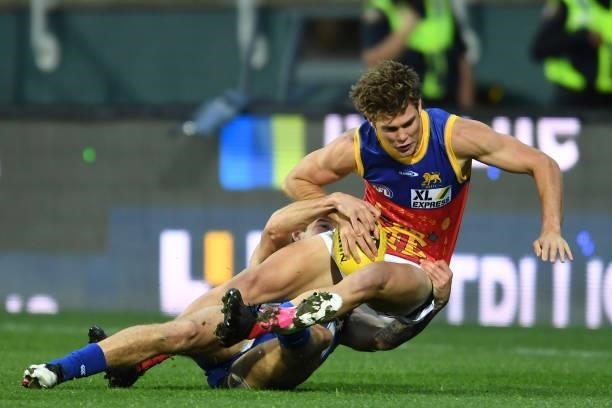 Deven Robertson of the Lions is tackled during the round 14 AFL match between the North Melbourne Kangaroos and the Brisbane Lions at Blundstone...