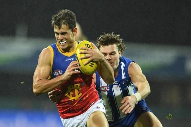 Deven Robertson of the Lions is tackled by Cameron Zurhaar of the Kangaroos during the round 14 AFL match between the North Melbourne Kangaroos and...