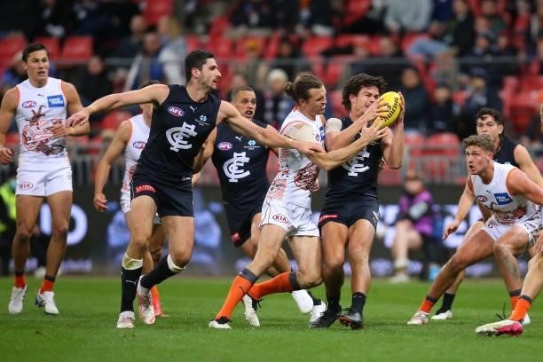 Jack Silvagni of the Blues is tackled by Phil Davis of the Giants during the round 14 AFL match between the Greater Western Sydney Giants and the...