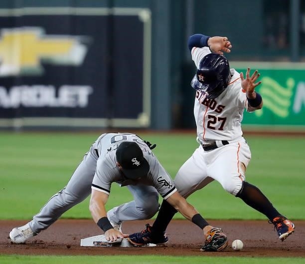 Jose Altuve of the Houston Astros slides into second base as Danny Mendick of the Chicago White Sox is unable to control the throw at Minute Maid...