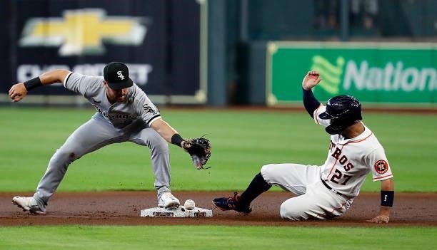 Jose Altuve of the Houston Astros slides into second base as Danny Mendick of the Chicago White Sox is unable to control the throw at Minute Maid...
