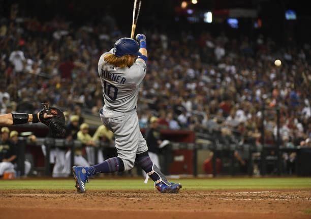 Justin Turner of the Los Angeles Dodgers makes contact with a pitch against the Arizona Diamondbacks at Chase Field on June 18, 2021 in Phoenix,...