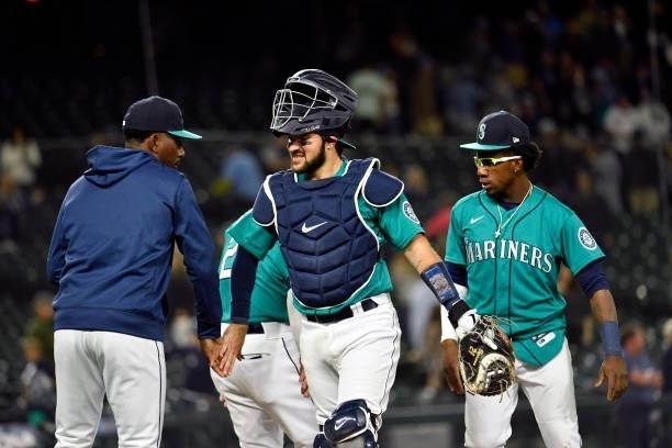 Luis Torrens of the Seattle Mariners low-fives teammates after the game against the Tampa Bay Rays at T-Mobile Park on June 18, 2021 in Seattle,...