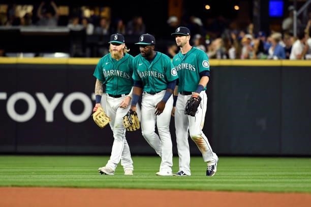 Jake Fraley, Taylor Trammell, and Mitch Haniger of the Seattle Mariners walk on the field during the game against the Tampa Bay Rays at T-Mobile Park...