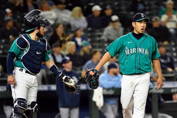 Yusei Kikuchi glove bumps with Luis Torrens of the Seattle Mariners during the game against the Tampa Bay Rays at T-Mobile Park on June 18, 2021 in...