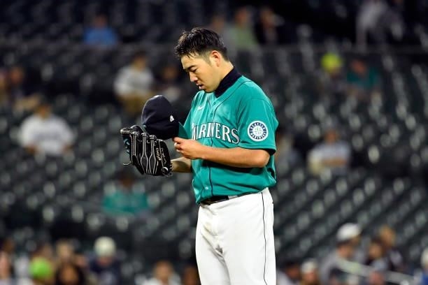 Yusei Kikuchi of the Seattle Mariners looks at notes in his hat during the game against the Tampa Bay Rays at T-Mobile Park on June 18, 2021 in...