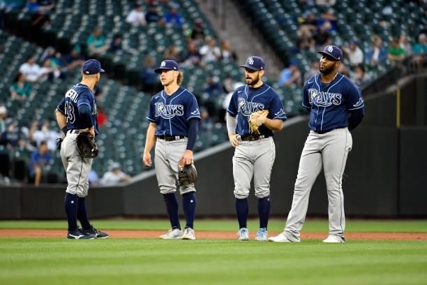 Mike Brosseau, Taylor Walls, Brandon Lowe, and Yandy Diaz of the Tampa Bay Rays stand on the field during the game against the Seattle Mariners at...