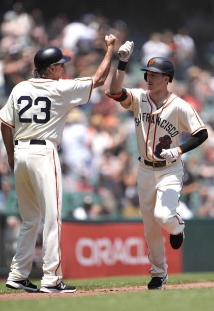 Mike Yastrzemski of the San Francisco Giants is congratulated by third base coach Ron Wotus after Yastrzemski hit a two-run home run against the...
