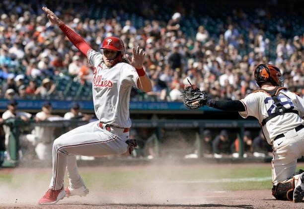 Alec Bohm of the Philadelphia Phillies scores sliding past a tag attempt by Buster Posey of the San Francisco Giants in the top of the seventh inning...
