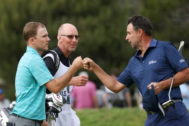 Russell Henley of the United States and Richard Bland of England fist bump on the 18th green during the third round of the 2021 U.S. Open at Torrey...