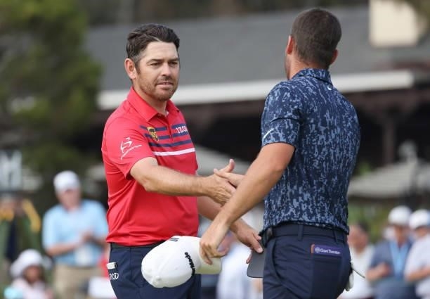 Louis Oosthuizen of South Africa and Matthew Wolff of the United States shake hands on the 18th hole during the third round of the 2021 U.S. Open at...