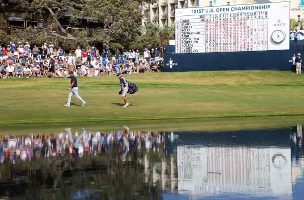 Bryson DeChambeau of the United States and caddie Tim Tucker walk up the 18th fairway during the third round of the 2021 U.S. Open at Torrey Pines...