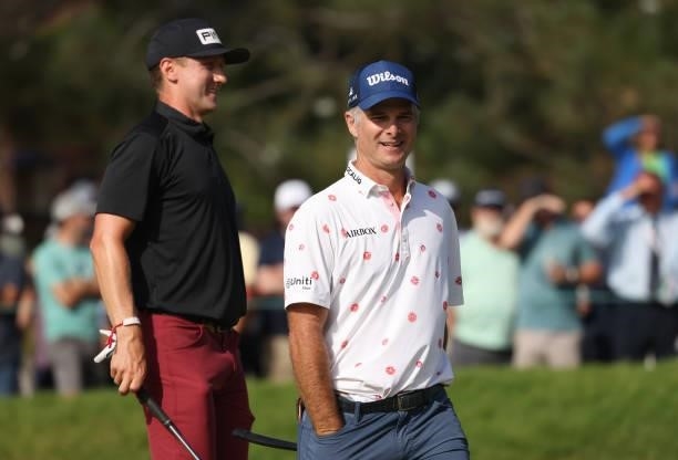 Kevin Streelman of the United States smiles after his putt on the 18th green as Mackenzie Hughes of Canada looks on during the third round of the...