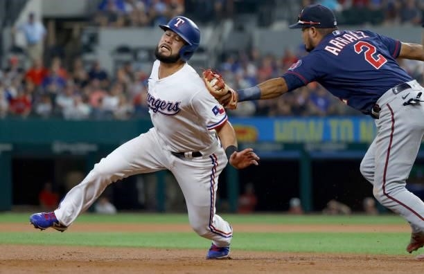 Isiah Kiner-Falefa of the Texas Rangers is caught in a rundown and tagged out by Luis Arraez of the Minnesota Twins during the first inning at Globe...