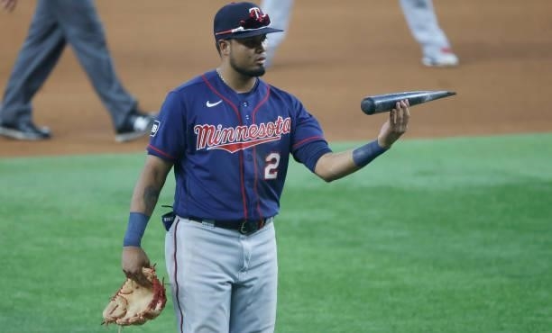 Luis Arraez of the Minnesota Twins picks up part of a broken bat belonging to Charlie Culberson of the Texas Rangers during the fifth inning at Globe...