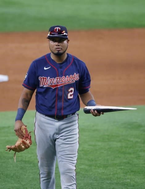 Luis Arraez of the Minnesota Twins picks up part of a broken bat belonging to Charlie Culberson of the Texas Rangers during the fifth inning at Globe...