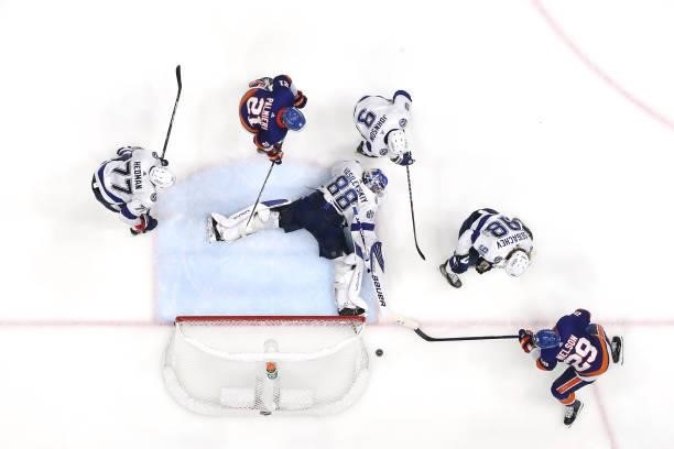 Andrei Vasilevskiy of the Tampa Bay Lightning makes a save as Brock Nelson of the New York Islanders reaches for the puck in Game Four of the Stanley...
