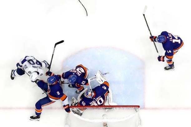 Nick Leddy of the New York Islanders gets tripped up with Blake Coleman of the Tampa Bay Lightning in front of the net in Game Four of the Stanley...