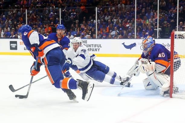 Ryan Pulock of the New York Islanders skates with the puck as Ross Colton of the Tampa Bay Lightning makes a play for it during the third period in...