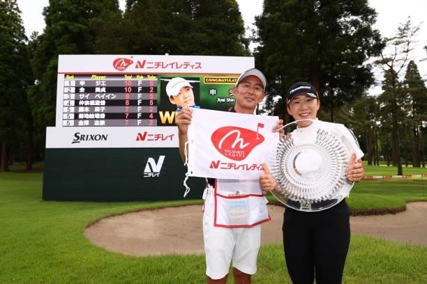 Jiyai Shin of South Korea poses with her caddie after winning the tournament through the playoff following the final round of Nichirei Ladies at...