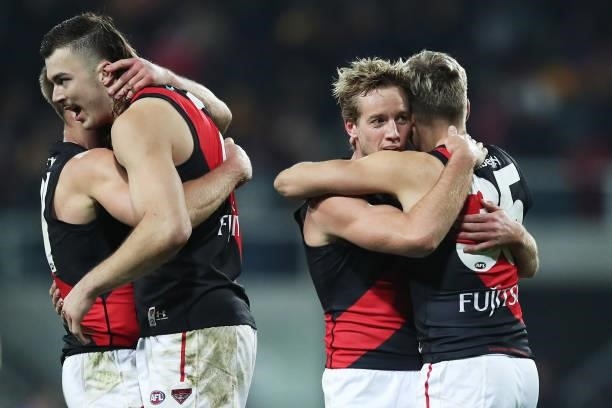 Dyson Heppell, Sam Draper, Darcy Parish and Matt Guelfi of the Bombers celebrate victory after the round 14 AFL match between the Hawthorn Hawks and...