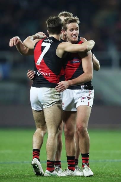 Zach Merrett and Darcy Parish of the Bombers celebrate victory with team mates after the round 14 AFL match between the Hawthorn Hawks and the...