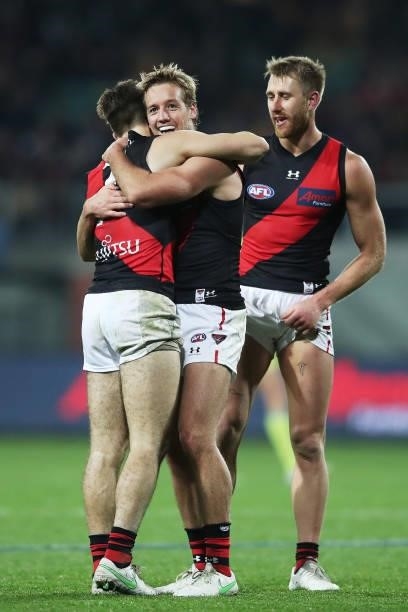Zach Merrett, Darcy Parish and Dyson Heppell of the Bombers celebrate victory after the round 14 AFL match between the Hawthorn Hawks and the...