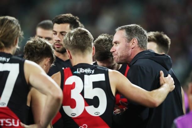 Bombers head coach Ben Rutten speaks to players at three quarter time during the round 14 AFL match between the Hawthorn Hawks and the Essendon...