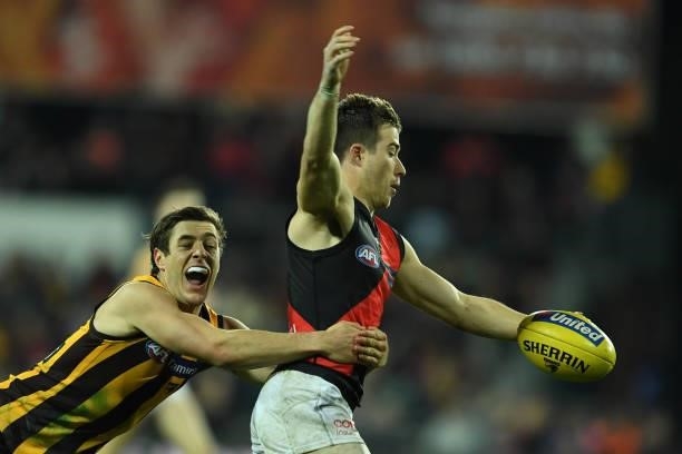 Zach Merrett of the Bombers is tackled by James Cousins of the Hawks during the round 14 AFL match between the Hawthorn Hawks and the Essendon...