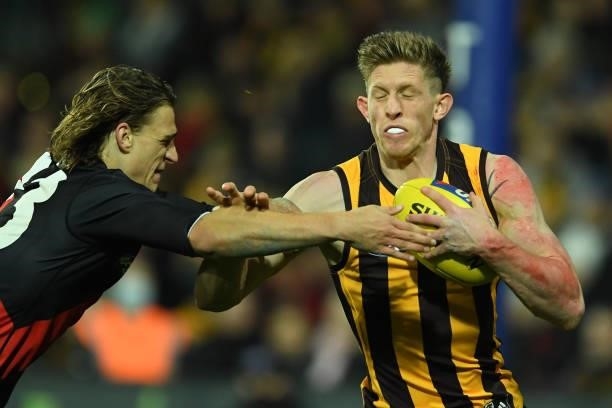 Sam Frost of the Hawks is tackled by Harrison Jones of the Bombers during the round 14 AFL match between the Hawthorn Hawks and the Essendon Bombers...