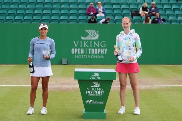 Alison Van Uytvanck of Belgium poses with the winner's trophy as runner-up Arina Rodionova of Australia stands beside her during the ITF W100 Final...