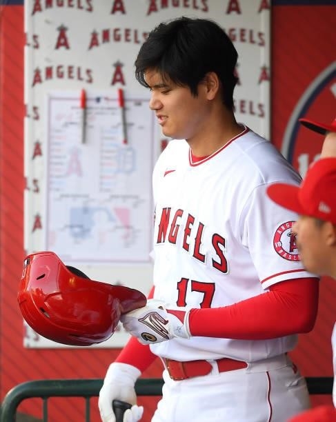 Shohei Ohtani of the Los Angeles Angels checks out his batting helmet in the dugout during the game against the Detroit Tigers at Angel Stadium of...