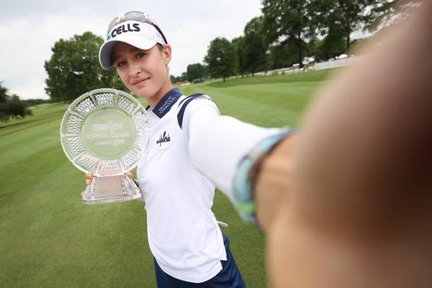 Nelly Korda poses for a simulated selfie with the trophy after winning the Meijer LPGA Classic for Simply Give at Blythefield Country Club on June...