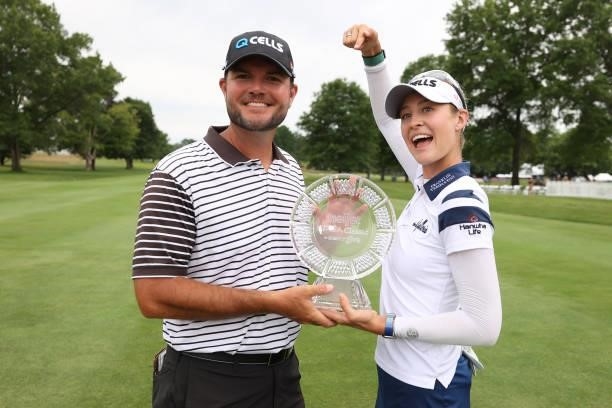 Nelly Korda and her caddie Jason McDede pose with the trophy after Nelly won the Meijer LPGA Classic for Simply Give at Blythefield Country Club on...