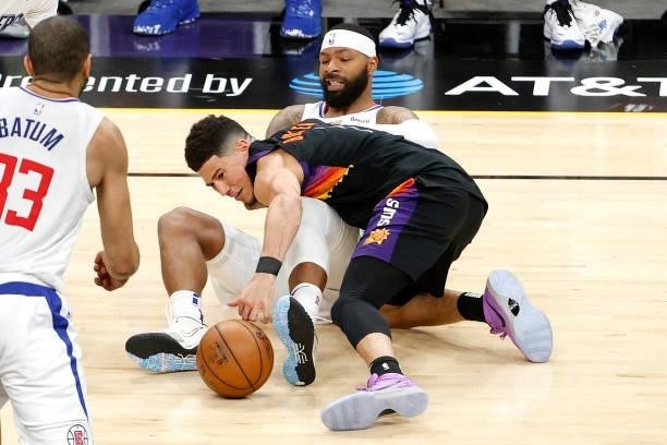 Devin Booker of the Phoenix Suns and Marcus Morris Sr. #8 of the Los Angeles Clippers compete for a loose ball in the second quarter during game one...
