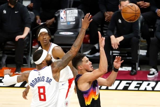 Devin Booker of the Phoenix Suns shoots against Marcus Morris Sr. #8 of the Los Angeles Clippers in the second quarter during game one of the Western...