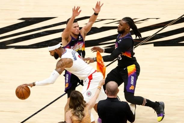 Marcus Morris Sr. #8 of the Los Angeles Clippers dribbles against Devin Booker and Jae Crowder of the Phoenix Suns as fans react in the second...