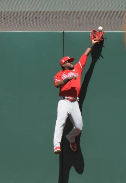 Odubel Herrera of the Philadelphia Phillies leaps at the wall as the ball bounces off for a two-run double off the bat of Brandon Crawford of the San...